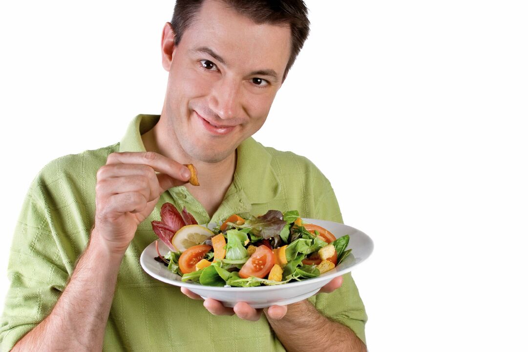 l'homme mange de la salade de légumes pour booster
